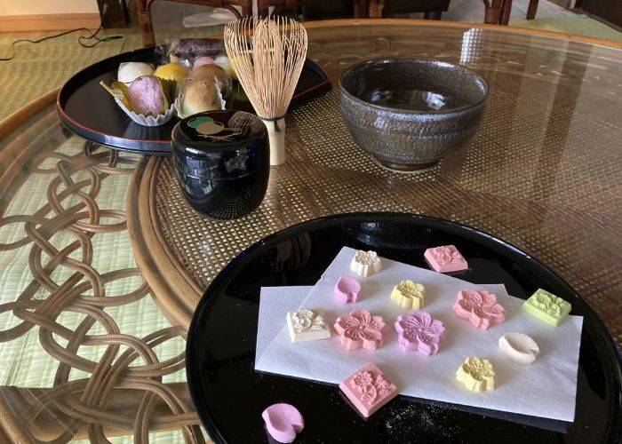 A private Japanese tea ceremony experience in Beppu. The table is covered with matcha tools and wagashi sweets.